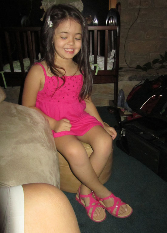 Trying to sit like a lady in her new sparkly dress and matching shoes