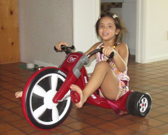 Barreling down the hallway at full speed on her tricycle