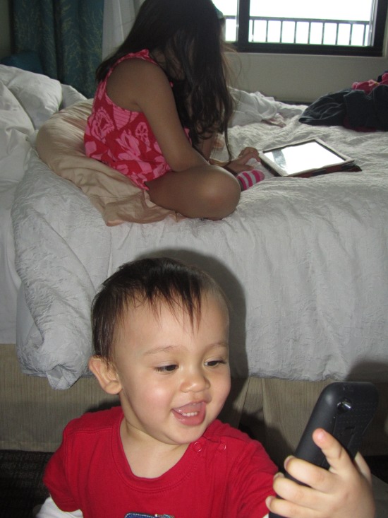 Yaya on the iPad ("the big thing") and Adik on the iPod ("Mama's black phone")