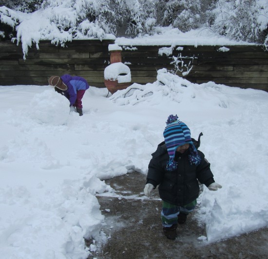 Yaya continues to work on the snowball while Adik checks things out (and Papa has shoveled bits of the back driveway)