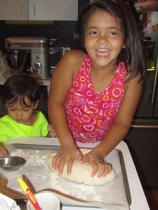Having fun kneading bread dough while Adik plays with flour