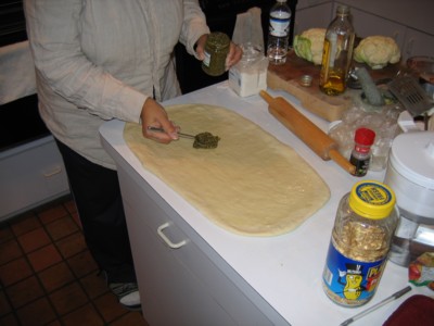 Begin spreading Pesto on the dough