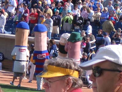 Sausages walking by the Cubs dugout, exiting the stadium after the race