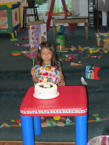 In her painting smock with her cake
