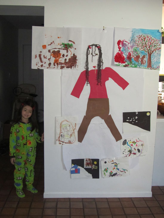 Yaya poses next to her "art wall"