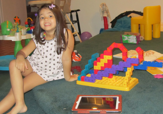 Posing with her building block sculpture of an elephant in an artsy zoo enclosure