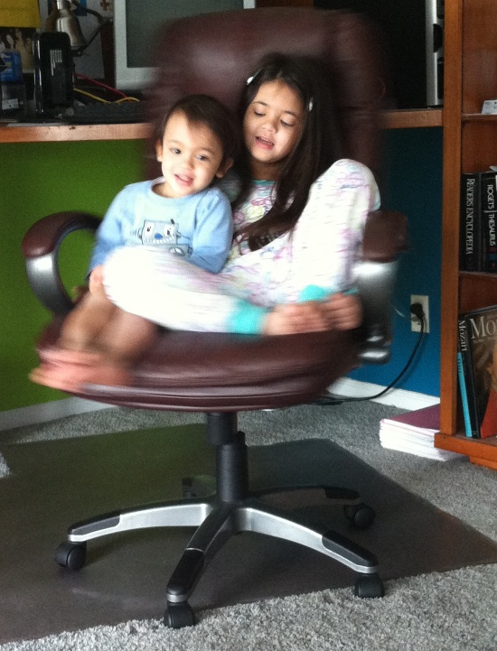 Yaya is Adik's seat belt while Papa spins them around in the swivel chair