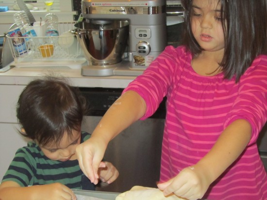 Yaya kneading bread while Adik plays with flour
