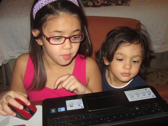 Playing games on pbskids.org while Adik looks on