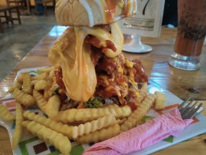 A really tall chicken zinger burger with cheese
