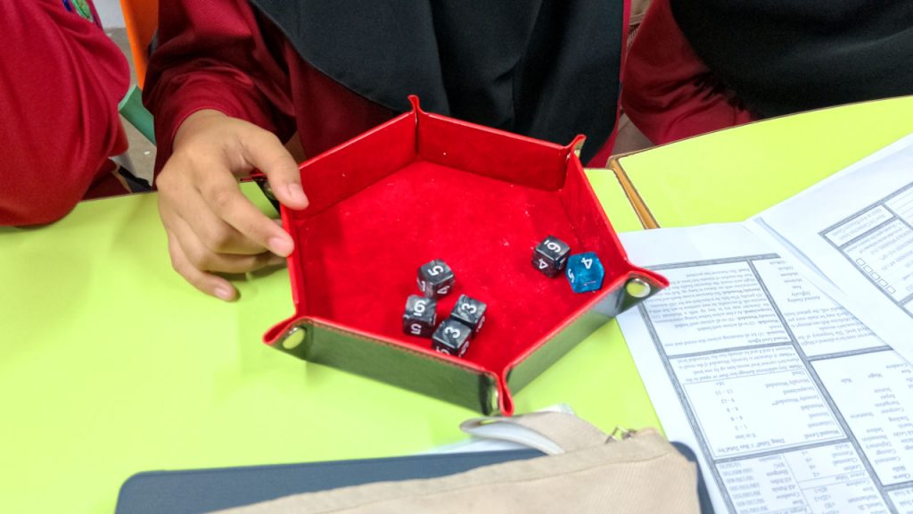 D6s in a red, hexagonal dice tray